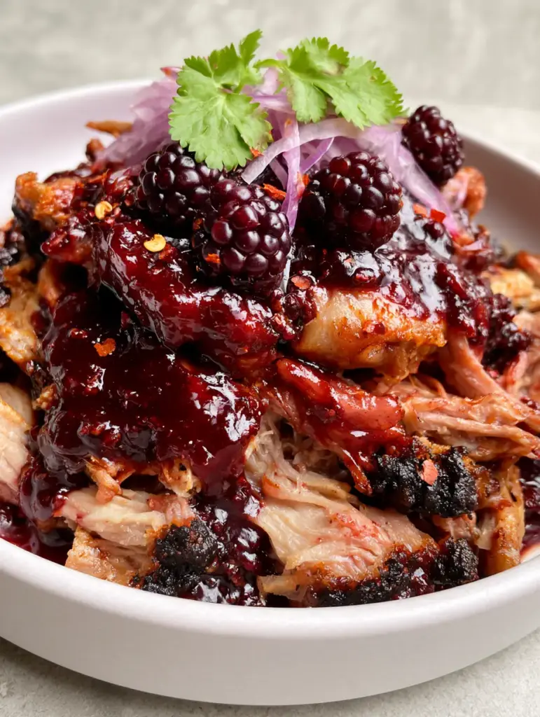 Black Raspberry Chipotle Pulled Pork with Smoky Heat and Sweet Glaze 2 Extreme close-up of glossy shredded pork with burgundy glaze and chipotle flakes. (black raspberry chipotle pulled pork)