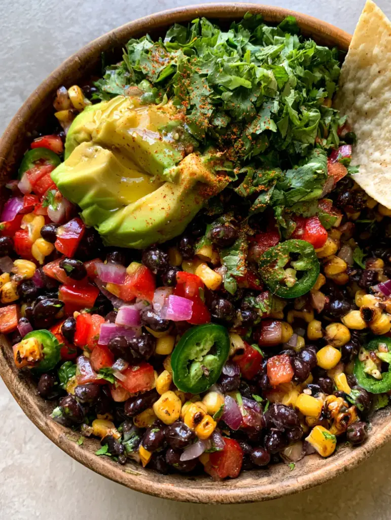 Cowboy Salad Recipe: The Ultimate Charred Corn and Black Bean Feast 2 Overhead smartphone photo of a vibrant cowboy salad in a wooden bowl with glossy beans and bright peppers. (cowboy salad)