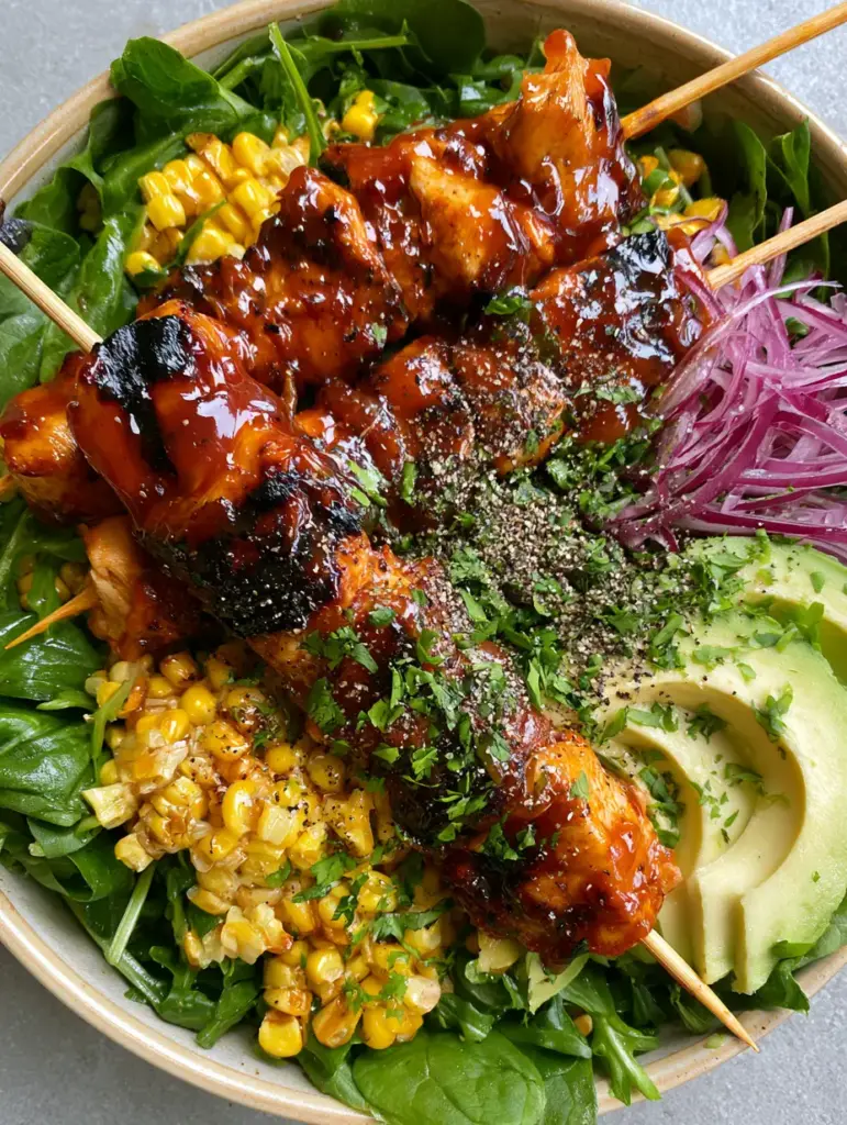 BBQ Chicken Skewer Salad with Honey Glaze and Fire-Roasted Corn 1 Grilled chicken breast skewers with deep char marks on a bed of arugula and spinach. (BBQ Chicken Skewer Salad)