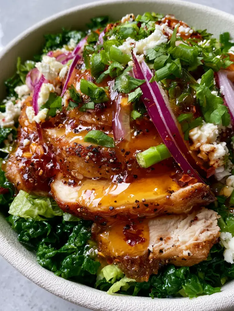 Honey Hot Chicken Salad with Glistening Amber Glaze and Massaged Kale 3 Extreme close-up of Honey Hot Chicken Salad highlighting the amber glaze and suspended red chili flakes on pan-seared chicken.