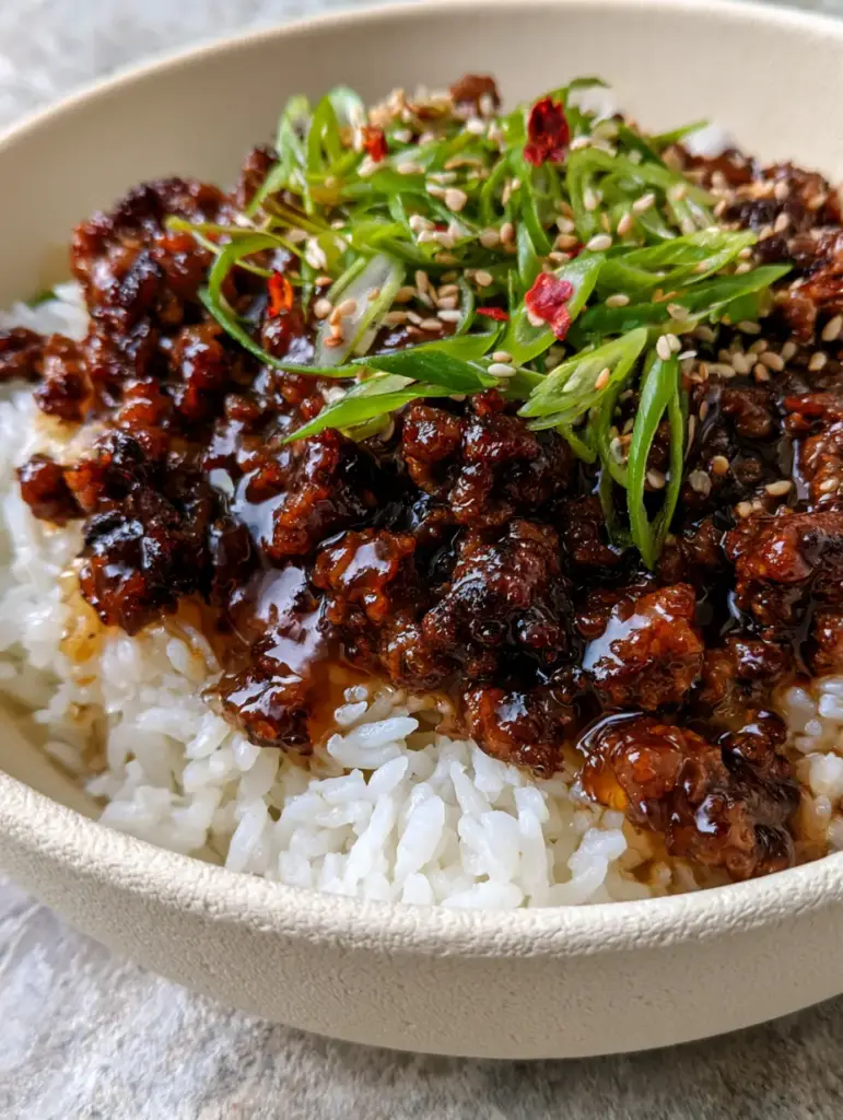 Honey Garlic Ground Beef Rice Bowl: The Ultimate 20-Minute Sticky Dinner 2 Extreme close-up of honey garlic ground beef rice bowl showing the translucent glistening sauce and caramelized beef edges.