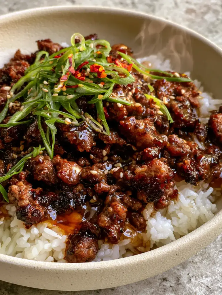 Honey Garlic Ground Beef Rice Bowl: The Ultimate 20-Minute Sticky Dinner 1 A handheld smartphone photo of a honey garlic ground beef rice bowl with steam rising from fluffy jasmine rice and vibrant garnishes.