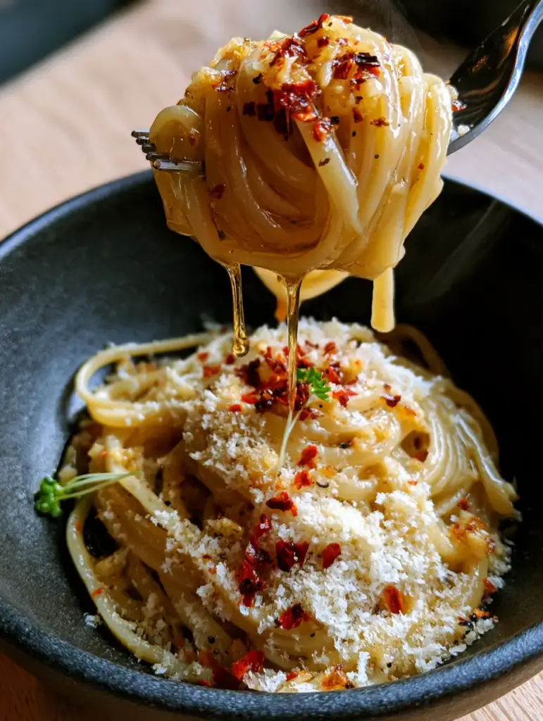 Detailed view of Garlic Butter Pasta showing the texture of toasted garlic and finely grated parmesan cheese.