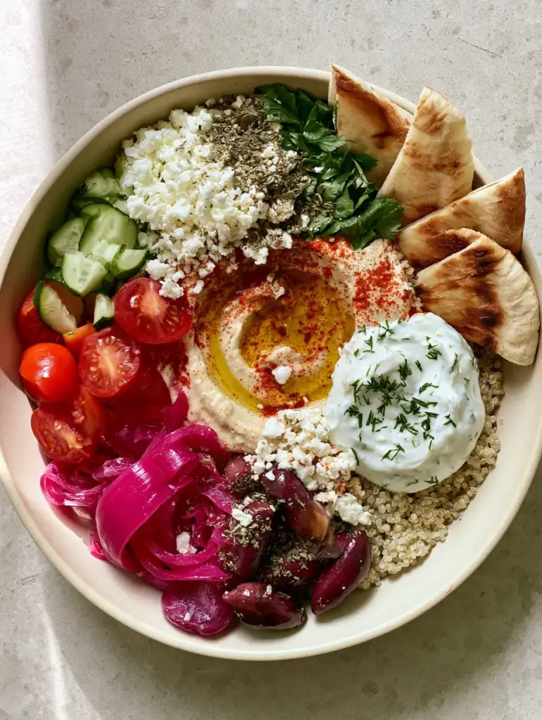 Close-up of fresh Mediterranean toppings including magenta pickled onions and ruby cherry tomatoes for a Mediterranean Mezze Bowl recipe.