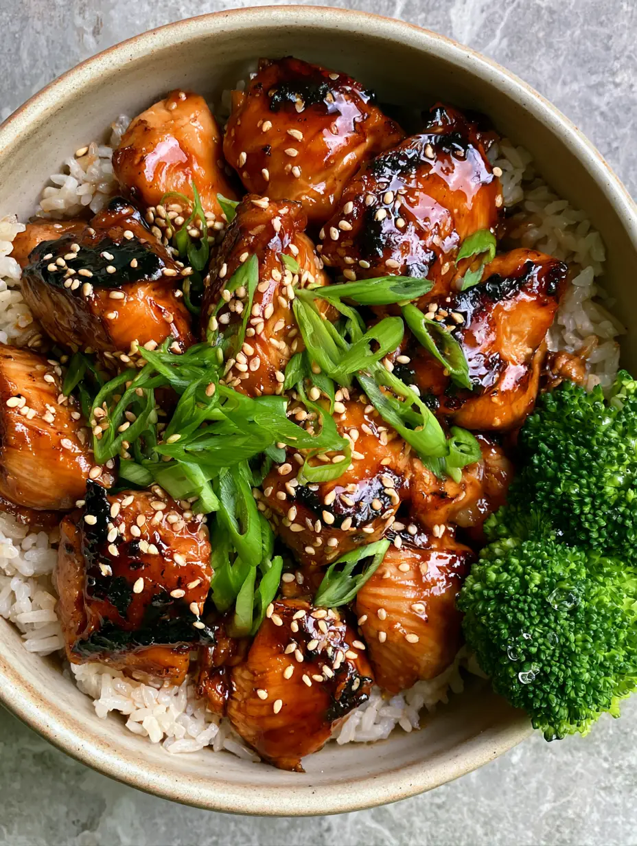 Top-down close-up of teriyaki chicken chunks with deep mahogany char, sesame seeds, and neon-green scallions. (teriyaki chicken)